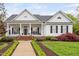 Charming home featuring a welcoming front porch with rocking chairs and professionally landscaped front yard at 1500 St Andrews Dr, Mebane, NC 27302