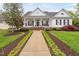 Inviting front exterior with a covered porch, manicured lawn, and charming landscaping for a welcoming curb appeal at 1500 St Andrews Dr, Mebane, NC 27302
