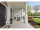 Comfortable front porch with rocking chairs, white columns, black shutters, and elegant details at 1500 St Andrews Dr, Mebane, NC 27302