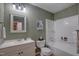 Bathroom with tub, shower, vanity, and olive green wood paneled walls at 1536 Dirkson Ct, Cary, NC 27511