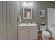 This bathroom features a white vanity and fixtures, a neutral green beadboard and framed mirror at 1536 Dirkson Ct, Cary, NC 27511