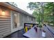 Outdoor deck with a wood table and yellow chairs surrounded by trees at 1536 Dirkson Ct, Cary, NC 27511