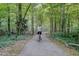 A paved path in the MacDonald Woods Park where a person rides a bike at 1536 Dirkson Ct, Cary, NC 27511