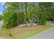 Aerial view showcases a home nestled among mature trees, lush landscaping, and a flowing creek at 2001 Virginia Dare Pl, Raleigh, NC 27610