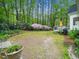 Expansive backyard with green lawn, tall trees, lush landscaping, and a wood deck at 2001 Virginia Dare Pl, Raleigh, NC 27610
