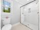Bathroom featuring a glass-enclosed shower, toilet, and window for natural light at 2001 Virginia Dare Pl, Raleigh, NC 27610