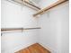 Walk in closet with wood floors and white walls with built in shelves and bars at 2001 Virginia Dare Pl, Raleigh, NC 27610