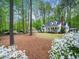 Beautiful landscaped yard with a charming white home nestled among mature trees at 2001 Virginia Dare Pl, Raleigh, NC 27610