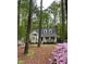 A charming two-story home is surrounded by blooming azaleas and tall, mature trees at 2001 Virginia Dare Pl, Raleigh, NC 27610