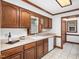Traditional kitchen featuring dark wood cabinetry, tile floors, and a bright window over the sink, creating a cozy atmosphere at 2001 Virginia Dare Pl, Raleigh, NC 27610