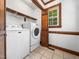 Laundry room with washer and dryer, wooden shelving and a window with natural light at 2001 Virginia Dare Pl, Raleigh, NC 27610