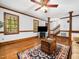Open living room with hardwood floors, traditional trim, a vintage trunk, and a staircase in the background at 2001 Virginia Dare Pl, Raleigh, NC 27610