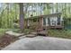 Charming brick home featuring a wooden deck and mature trees create a serene backyard setting at 208 Clark Lake Rd, Durham, NC 27707