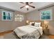 This staged bedroom features a large bed, hardwood floors, and natural light through the large windows at 208 Clark Lake Rd, Durham, NC 27707