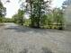 Gravel driveway leading towards a serene lake with lush greenery along the banks at 208 Clark Lake Rd, Durham, NC 27707