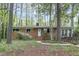 Charming brick ranch-style home with a landscaped front yard and inviting entryway surrounded by mature trees at 208 Clark Lake Rd, Durham, NC 27707
