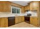 Well-lit kitchen with wooden cabinets, stainless steel appliances, and a view to the outdoors at 208 Clark Lake Rd, Durham, NC 27707