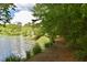 Scenic lake view with tree-lined path and lush greenery at 208 Clark Lake Rd, Durham, NC 27707