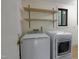 Bright laundry room with modern appliances and convenient open shelving for storage solutions at 208 Clark Lake Rd, Durham, NC 27707