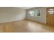 Open living room with hardwood floors, a large window, and a front door, creating a welcoming space at 208 Clark Lake Rd, Durham, NC 27707