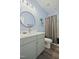 Stylish bathroom featuring a modern vanity, round mirror, and a shower-tub combination, creating a relaxing space at 21 Davidson St, Clayton, NC 27527