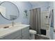 Stylish bathroom featuring a modern vanity, round mirror, and a shower-tub combination, creating a relaxing space at 21 Davidson St, Clayton, NC 27527
