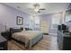Bright bedroom featuring wood-look floors, a ceiling fan, and light purple walls at 21 Davidson St, Clayton, NC 27527