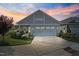Charming home featuring a two-car garage, well-manicured lawn, and a beautiful sunset in the background at 21 Davidson St, Clayton, NC 27527