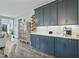 Open kitchen with blue cabinets, white countertops, wine rack, and stainless steel appliances, creating a stylish and functional space at 21 Davidson St, Clayton, NC 27527