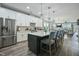 Spacious kitchen with white cabinets, stainless steel appliances, island with seating, and hardwood floors at 21 Davidson St, Clayton, NC 27527
