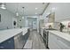 Bright kitchen with white cabinets, stainless steel appliances, an island with seating, and hardwood floors at 21 Davidson St, Clayton, NC 27527