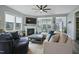 Bright living room featuring large windows, a fireplace, a ceiling fan, and comfortable, stylish seating at 21 Davidson St, Clayton, NC 27527