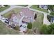 Aerial view of a gray home, screened porch, patio, and driveway with three cars on a meticulously landscaped lot at 2113 Rockwall Farms Ln, Fuquay Varina, NC 27526