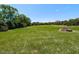 Large backyard with well-maintained grass and a stone fire pit, perfect for outdoor gatherings at 2113 Rockwall Farms Ln, Fuquay Varina, NC 27526