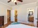 Bright bedroom with hardwood floors, ceiling fan, and en suite bathroom with double doors and walk-in closet at 2113 Rockwall Farms Ln, Fuquay Varina, NC 27526