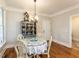 Bright dining area with hardwood floors, elegant chandelier, and decorative china cabinet, perfect for gatherings at 2113 Rockwall Farms Ln, Fuquay Varina, NC 27526
