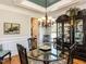 Formal dining room with elegant chandelier, glass table, and decorative china cabinet at 2113 Rockwall Farms Ln, Fuquay Varina, NC 27526