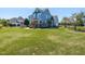 Expansive front yard of a charming two-story home with beautifully maintained landscaping and mature trees at 2113 Rockwall Farms Ln, Fuquay Varina, NC 27526