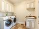 Functional laundry room with modern washer and dryer, built-in cabinets, and a utility sink at 2113 Rockwall Farms Ln, Fuquay Varina, NC 27526