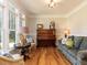 Cozy living room with hardwood floors, large window, and comfortable seating area featuring a piano at 2113 Rockwall Farms Ln, Fuquay Varina, NC 27526