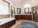 Elegant main bathroom with a soaking tub, dual vanities and tile flooring at 2113 Rockwall Farms Ln, Fuquay Varina, NC 27526