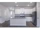 Open-concept kitchen features white cabinets, stainless appliances, and an island with granite countertops at 2122 Willow Gln Dr, Graham, NC 27253