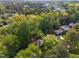 A high aerial view reveals homes nestled into a mature green forest at 216 Burkwood Ln, Raleigh, NC 27609