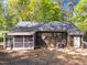 The backyard features a screened porch, wooden siding and mature trees at 216 Burkwood Ln, Raleigh, NC 27609
