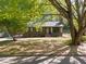 Charming home with olive green siding, white trim, and mature trees providing shade at 216 Burkwood Ln, Raleigh, NC 27609