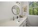 Bright bathroom featuring a round mirror and quartz countertop with a large window at 216 Dairyland Rd, Chapel Hill, NC 27516