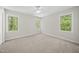 Neutral bedroom with white trim, fan and carpet and three large windows at 216 Dairyland Rd, Chapel Hill, NC 27516
