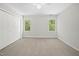 Neutral bedroom with white trim, fan and carpet, large windows and closet at 216 Dairyland Rd, Chapel Hill, NC 27516