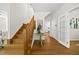 Welcoming foyer with hardwood floors, staircase, and view into a bright, modern kitchen at 216 Dairyland Rd, Chapel Hill, NC 27516