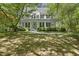 Charming two-story home featuring a welcoming front porch surrounded by mature trees and lush landscaping at 216 Dairyland Rd, Chapel Hill, NC 27516